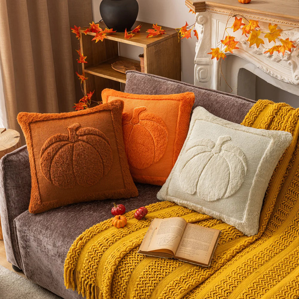 Pumpkin pillow covers in three colors on a sofa