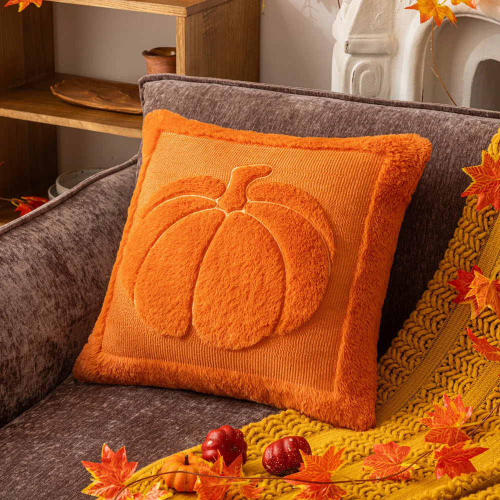 Orange pumpkin pillow cover on a gray sofa with a mustard throw