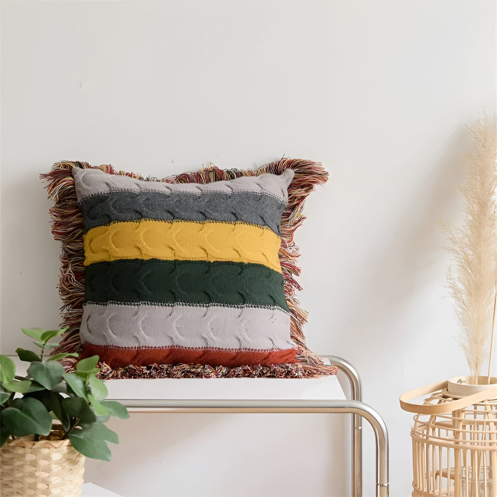 Striped cable knit cushion on a white bench