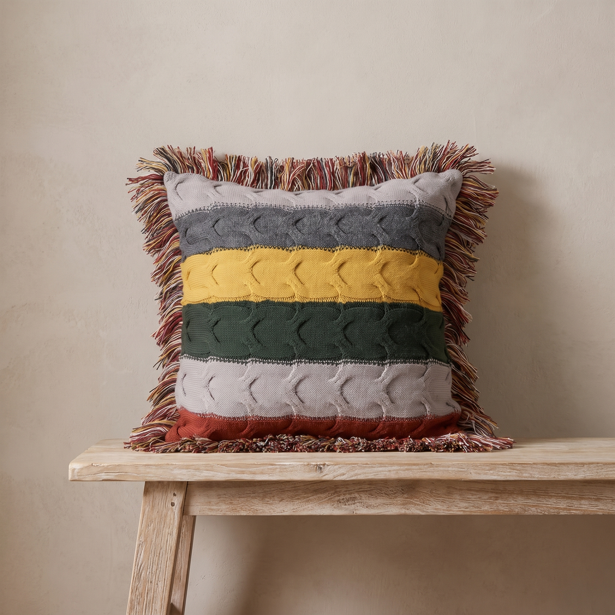 Aino striped cable knit cushion with fringe on a white oak bench