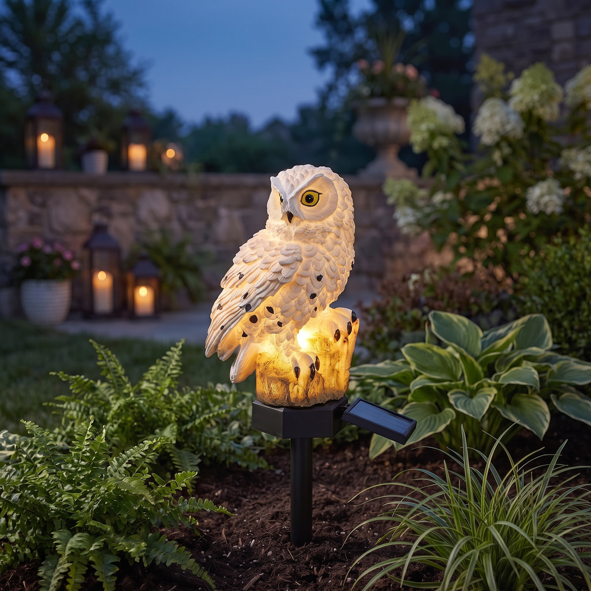 Alta solar owl garden light glowing at dusk among low plants