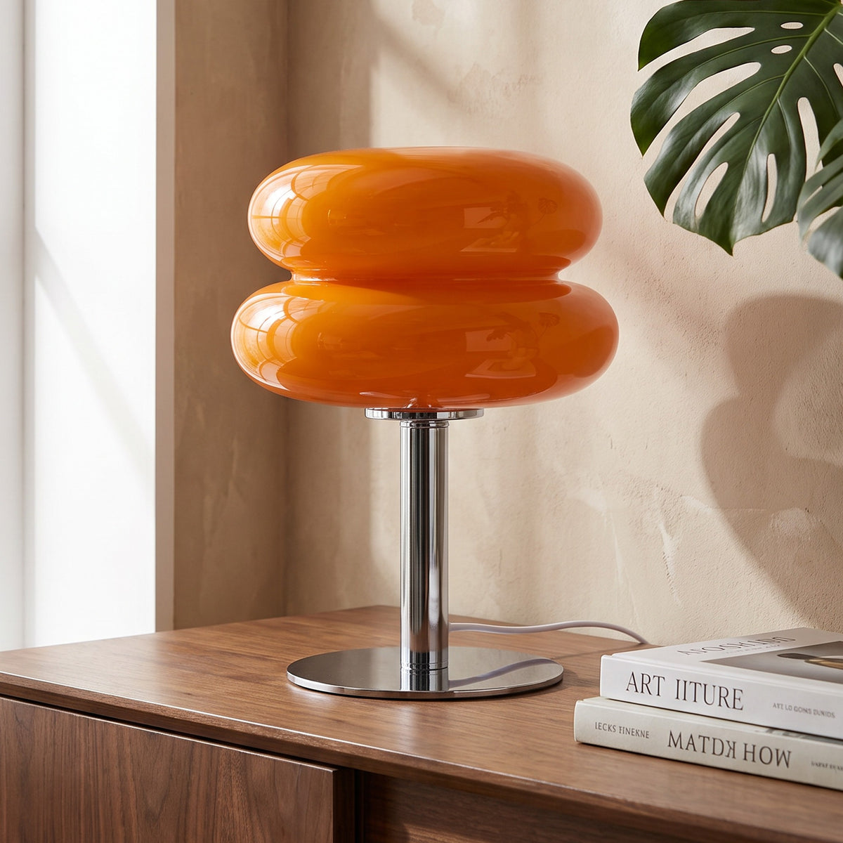 Annika glass table lamp in orange on a walnut sideboard