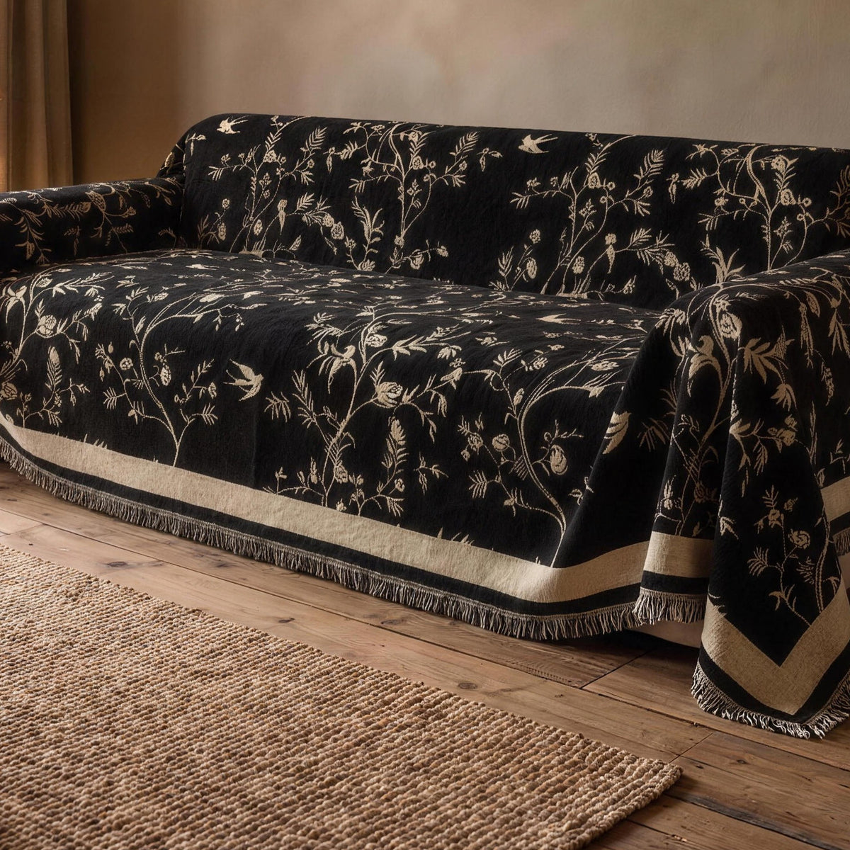Chenille sofa cover in Black with a cream floral jacquard on a sofa