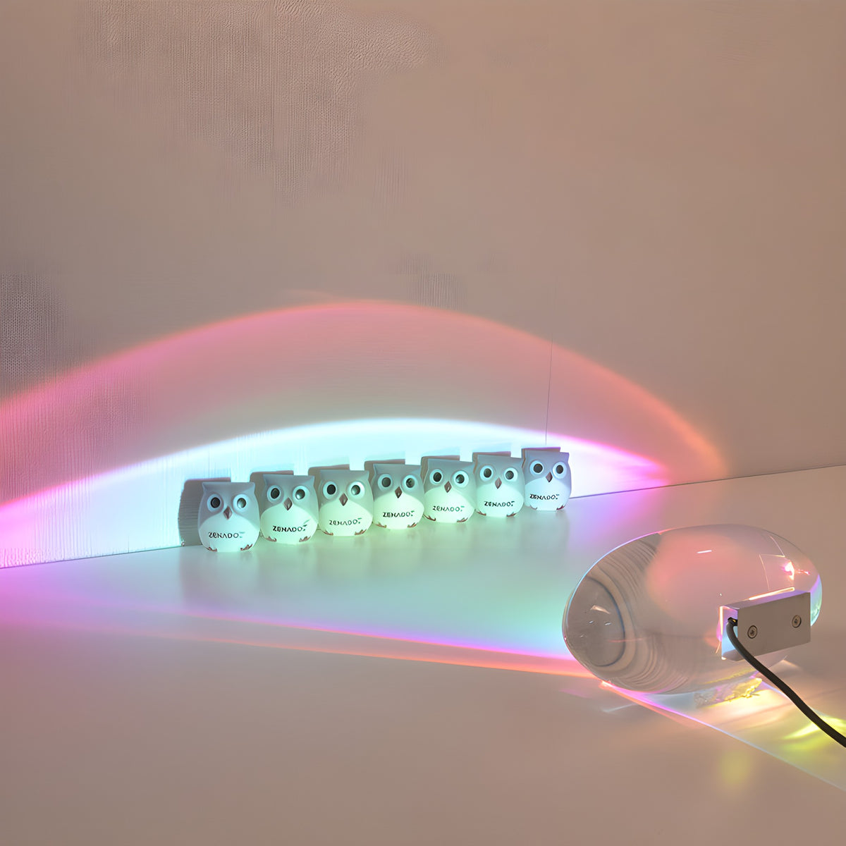 Elna projection lamp with its USB cord, colored light over a row of small figures