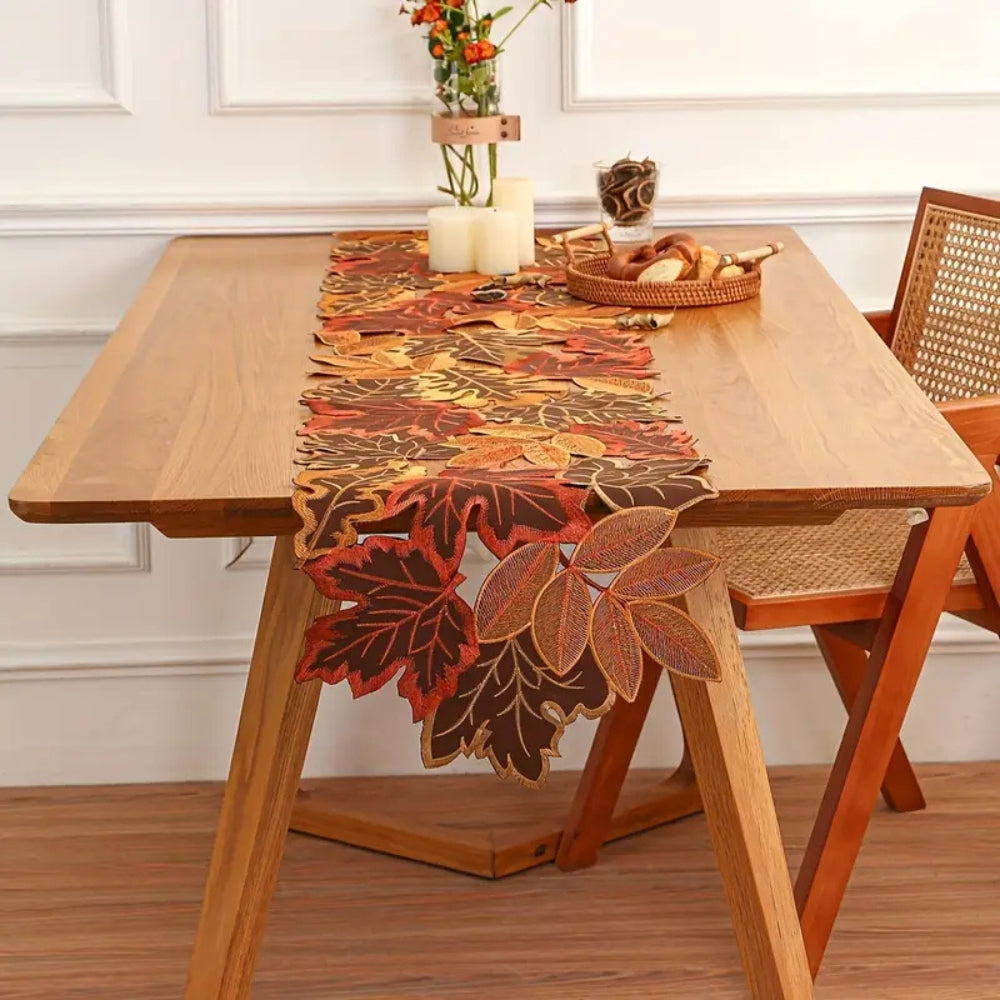 Embroidered leaf table runner down a light wood table by a window