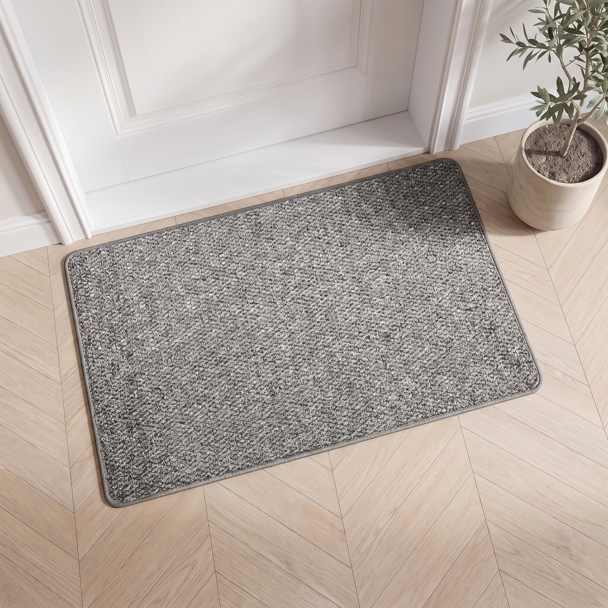 Faux jute door mat in gray inside a white front door