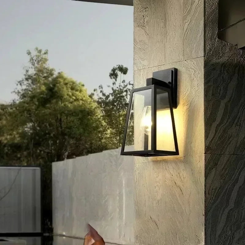 Fjell lantern on an exterior stone wall at dusk