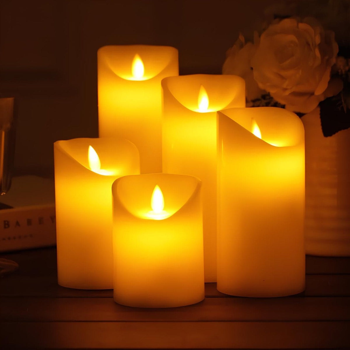 Five classic flameless pillar candles lit on a table