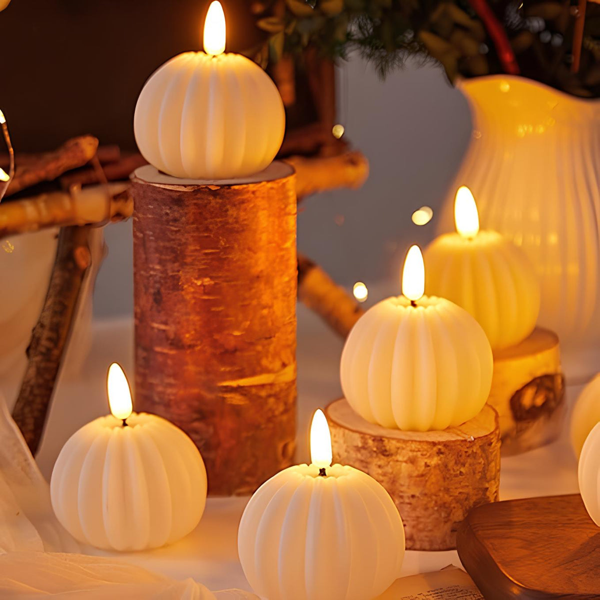 Pumpkin flameless candles lit beside a birch log