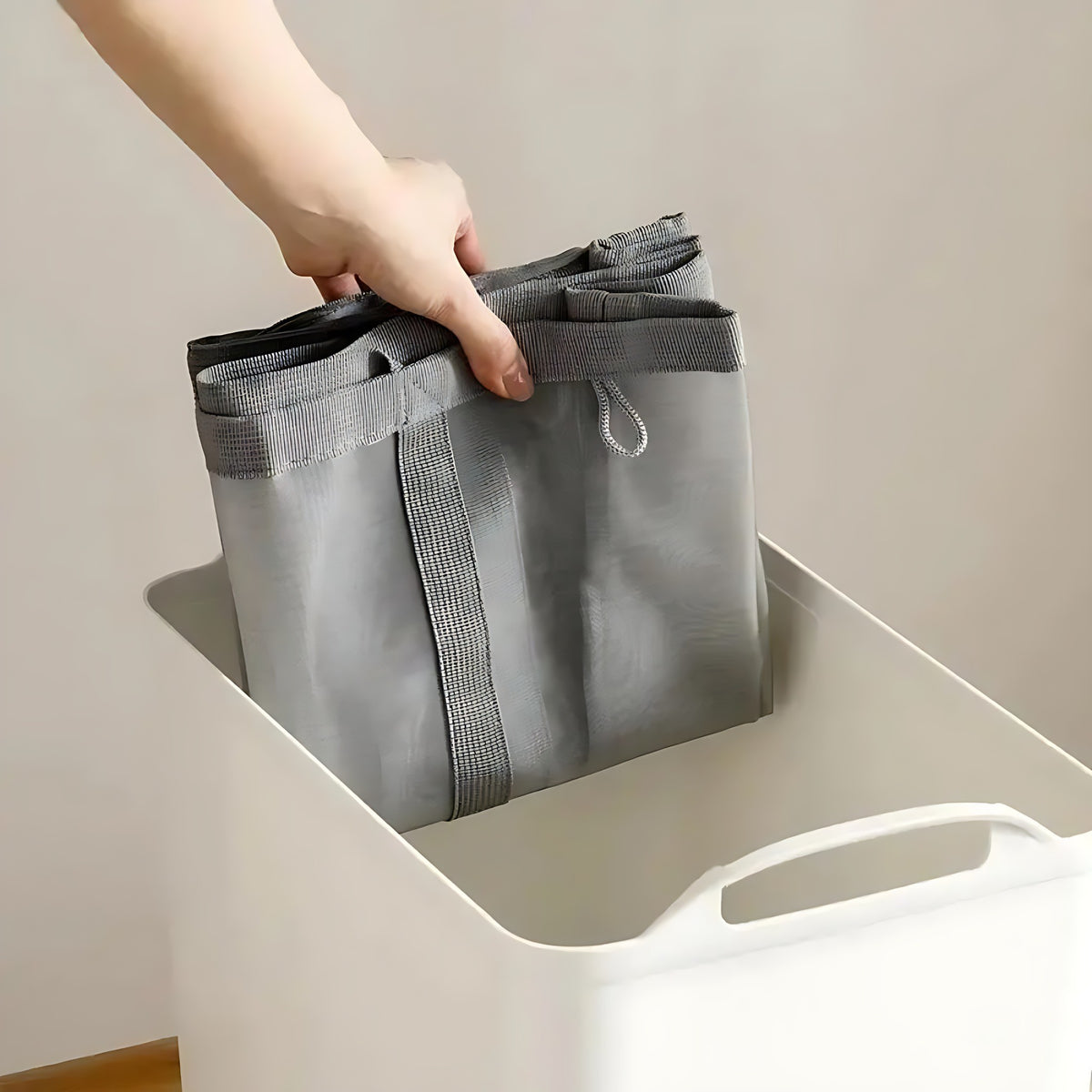 Gray mesh laundry basket folded flat into a box