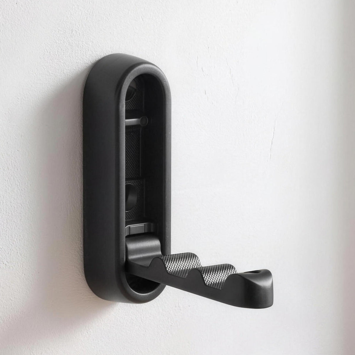 Folding wall hook in Black opened out on a white wall
