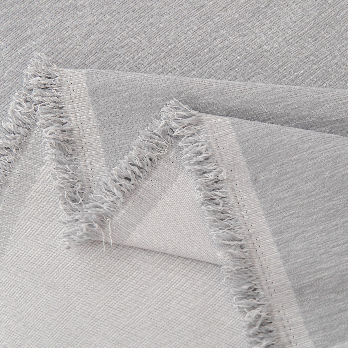 Close view of the light gray fringed edge
