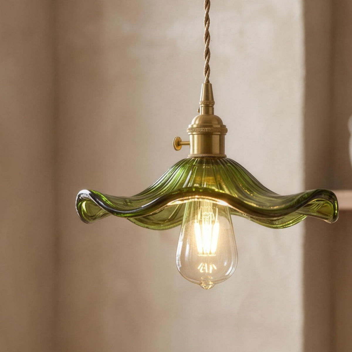 Hanne pendant light, green ruffled glass shade with a gold tone socket, lit