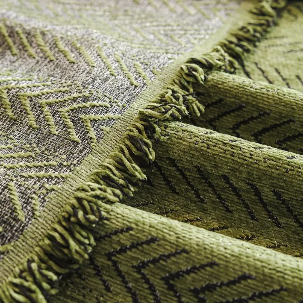 Close view of the tasseled edge of the green chenille cover