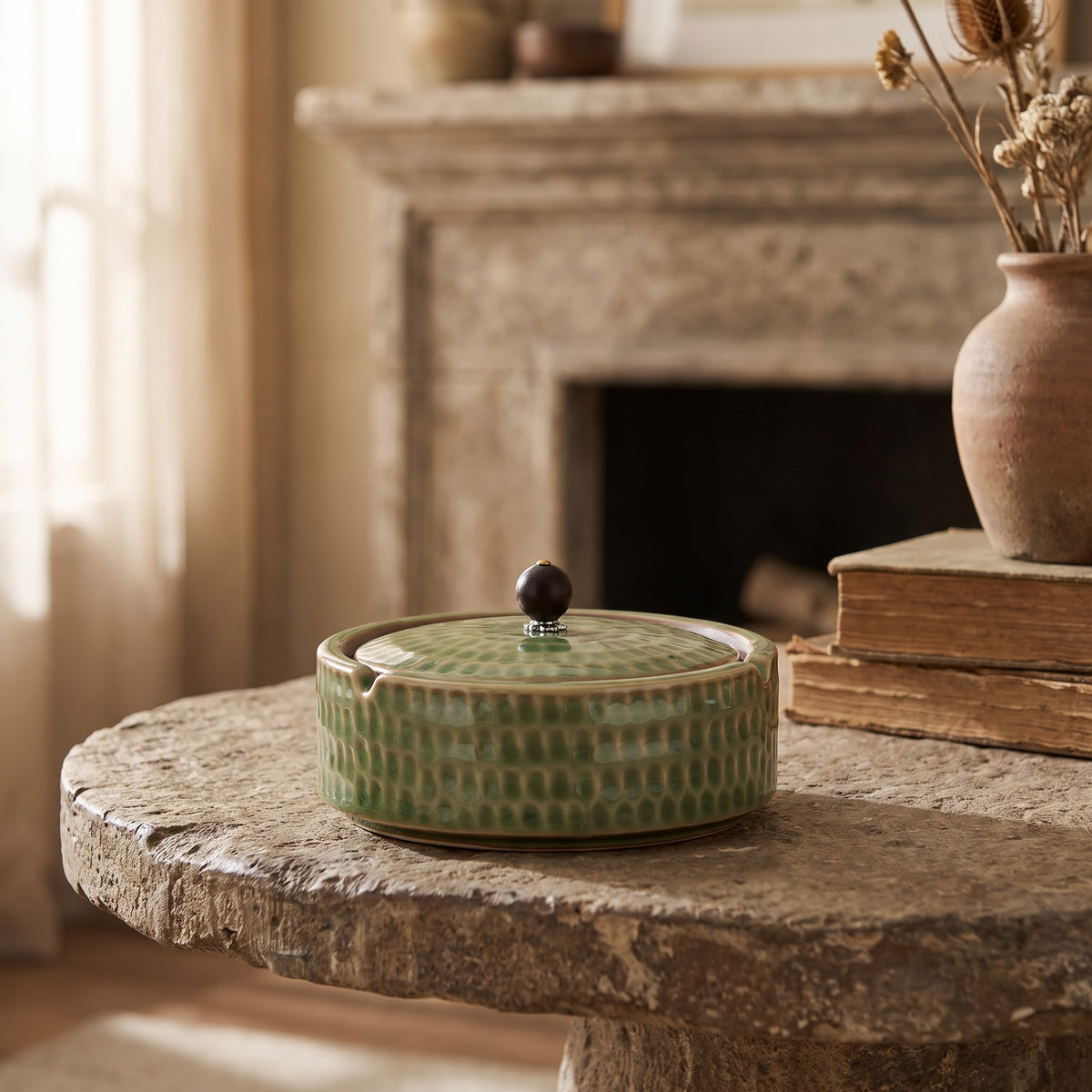 Hilde ceramic ashtray with lid on a stone side table by a fireplace