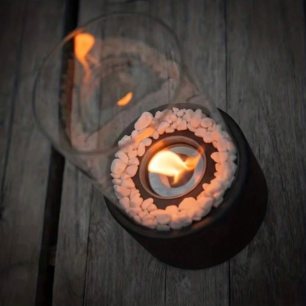 Top view of the Horten fire lamp lit, with white stones around the burner