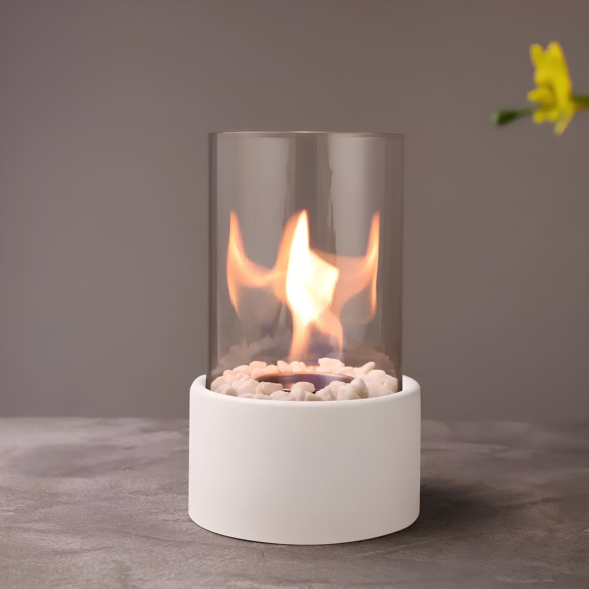 Horten fire lamp in white lit on a gray surface