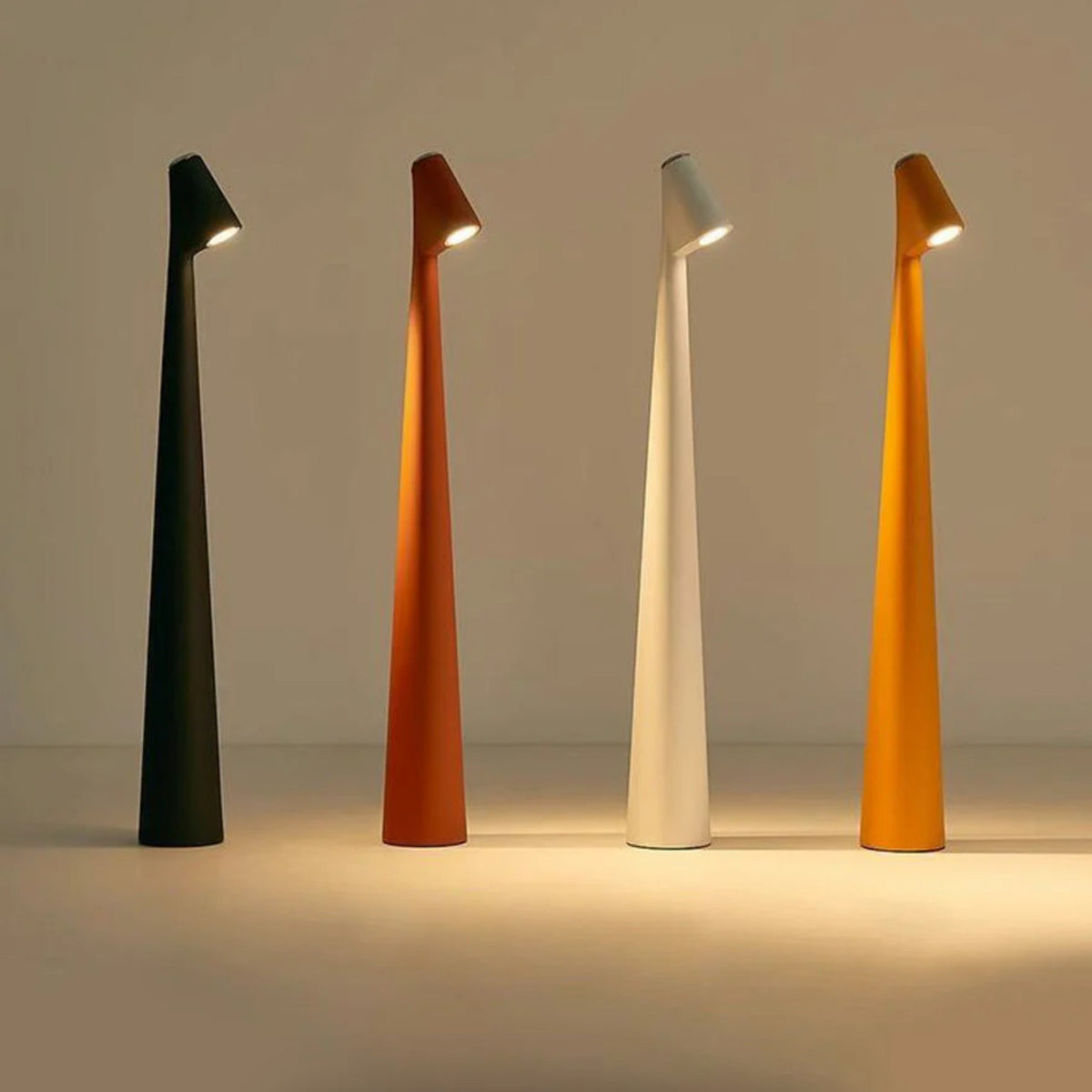 Iben cordless table lamps in black, brown, white and orange, lit in a row