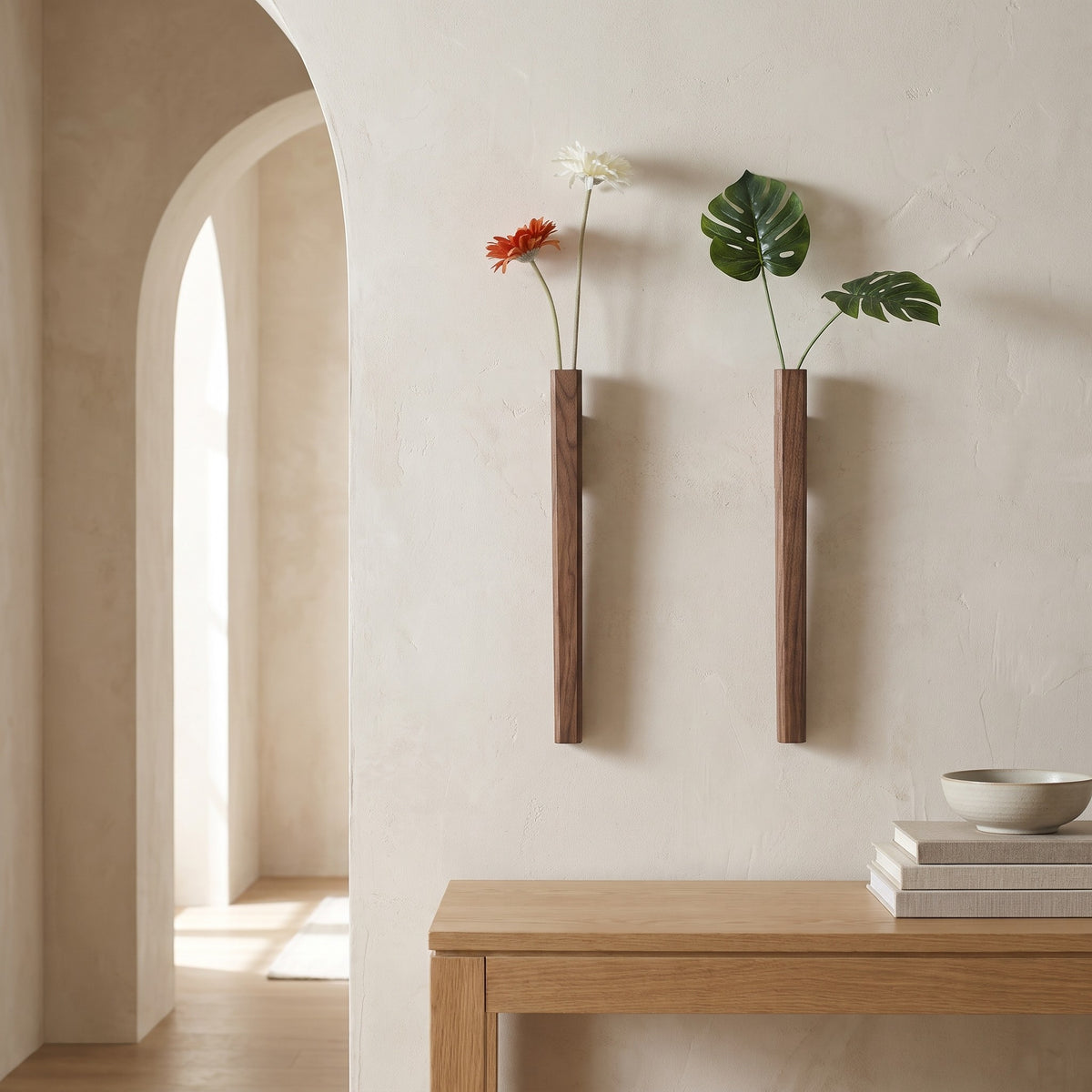 Two Idun walnut wall vases with flowers above a console