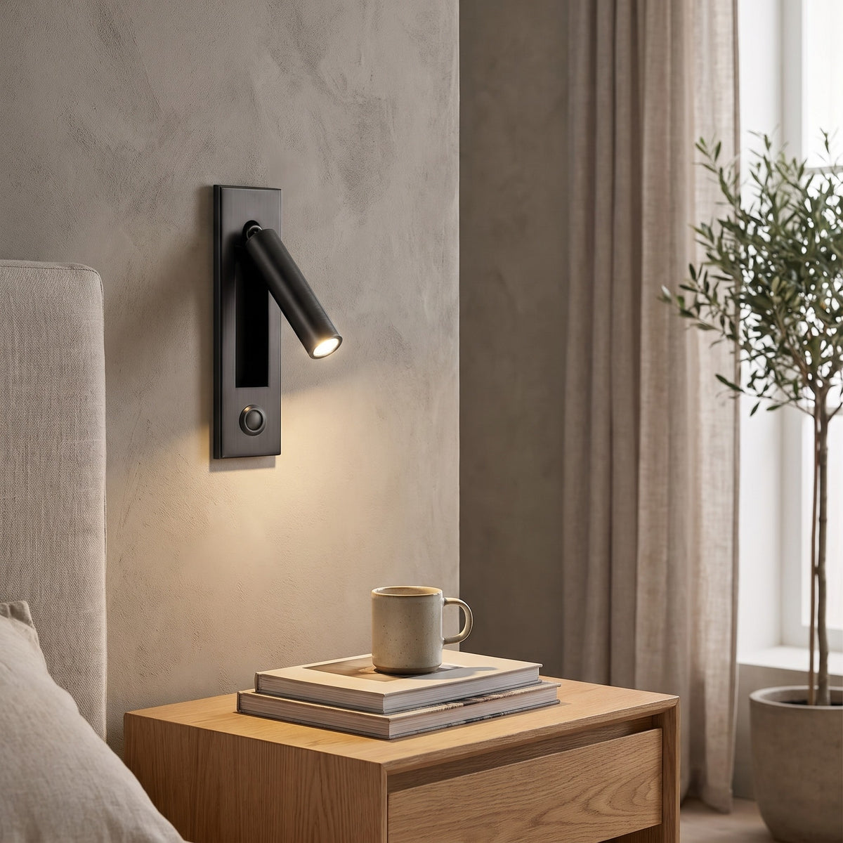 Kaia LED reading wall light above a nightstand with books and a mug