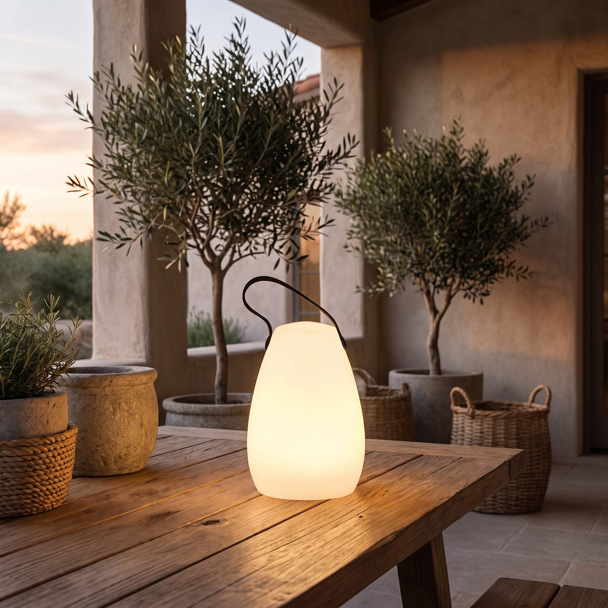 Vase shaped Kari cordless lamp glowing on an outdoor table