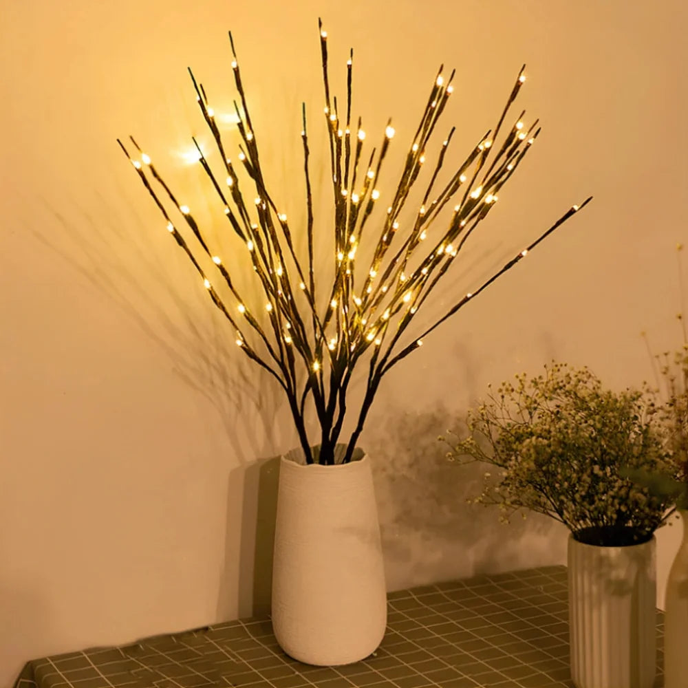 Lighted willow branches in a white vase