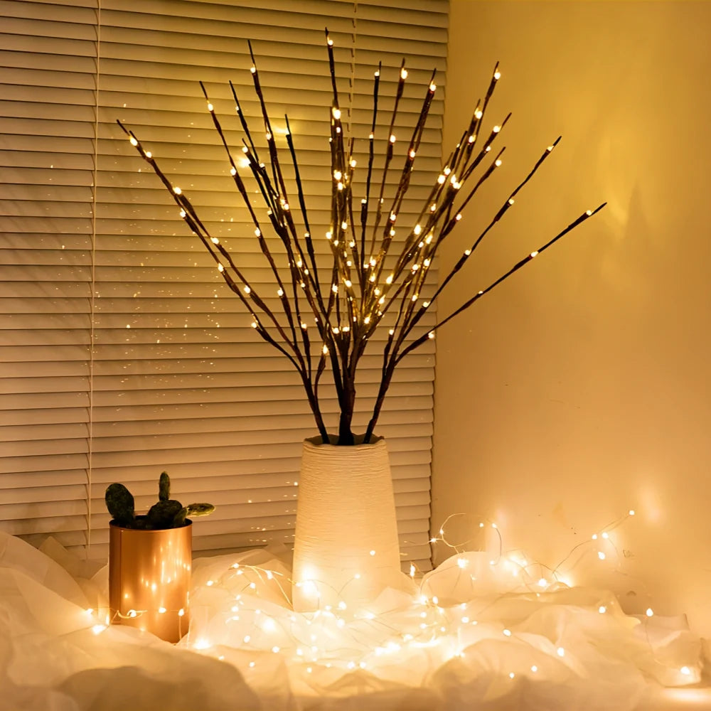 Lighted willow branches in a vase on a table
