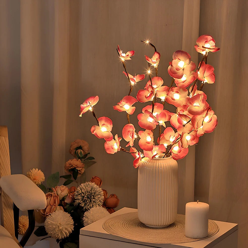 Lighted pink orchid branches in a vase