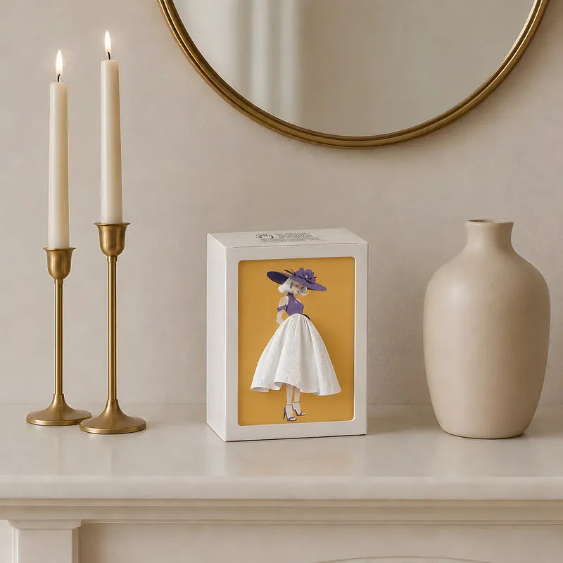 Lighted tissue box in Couture on a mantel beside two candles and a vase