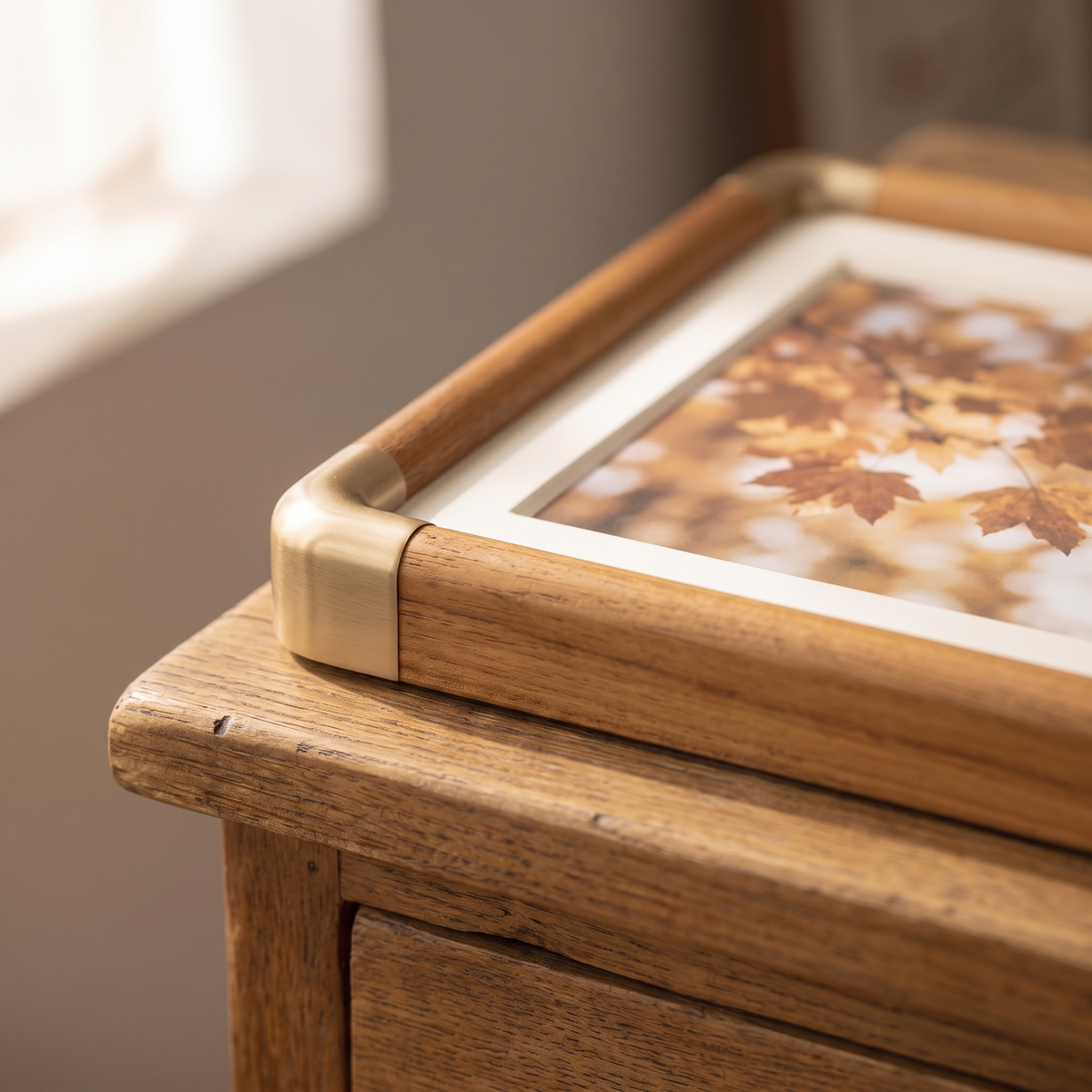 Close view of a Mabel frame brass tone corner on a wood dresser