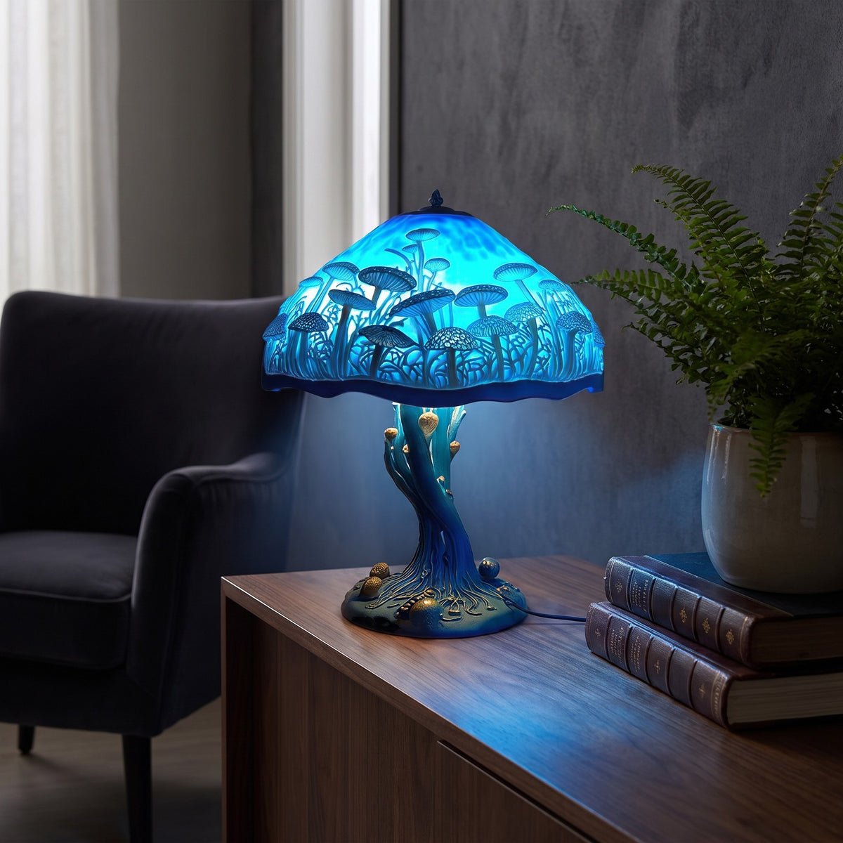 Blue Majken mushroom lamp lit on a desk beside books