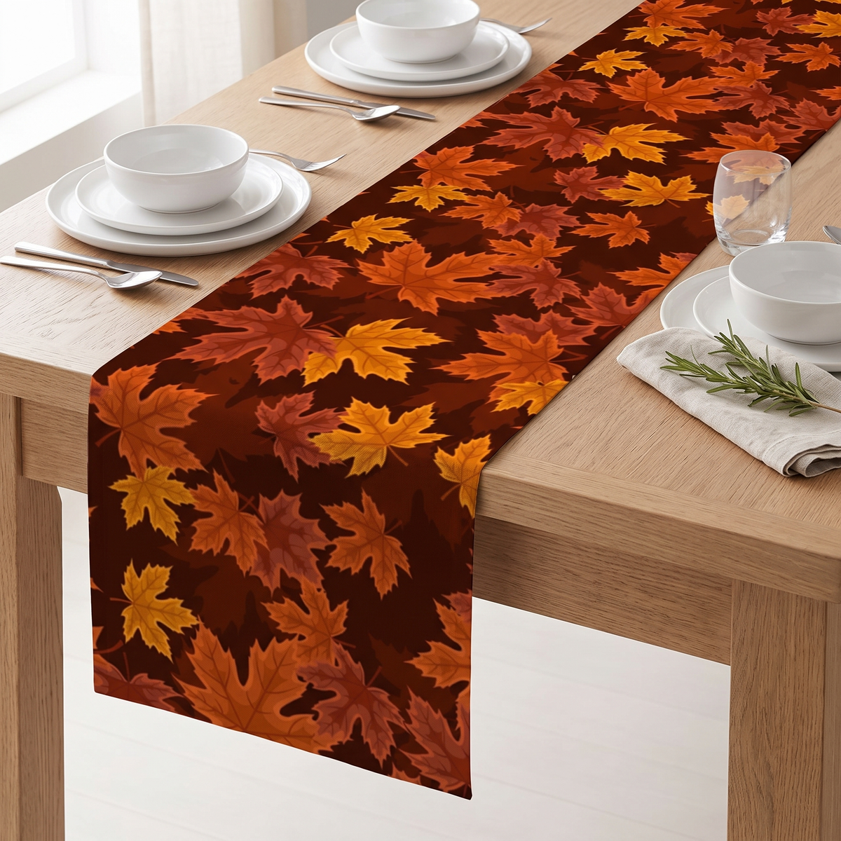 Maple leaf print table runner on a light oak dining table with white plates
