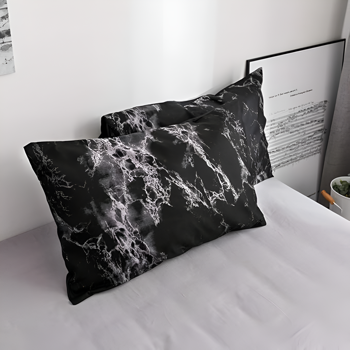 Two black marble pillowcases on a gray sheet