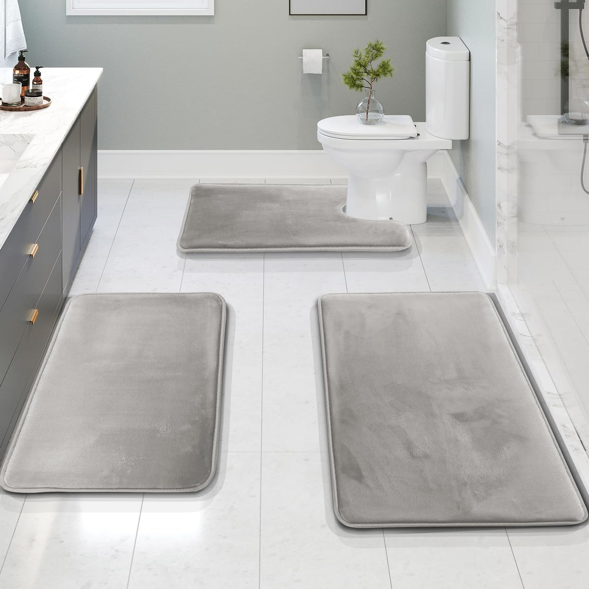 Light gray bath mat set around a toilet and vanity