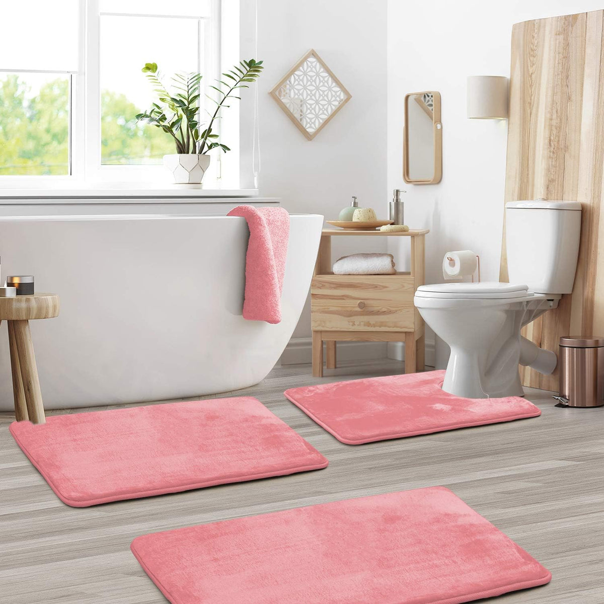 Pink bath mat set in a bathroom with a freestanding tub