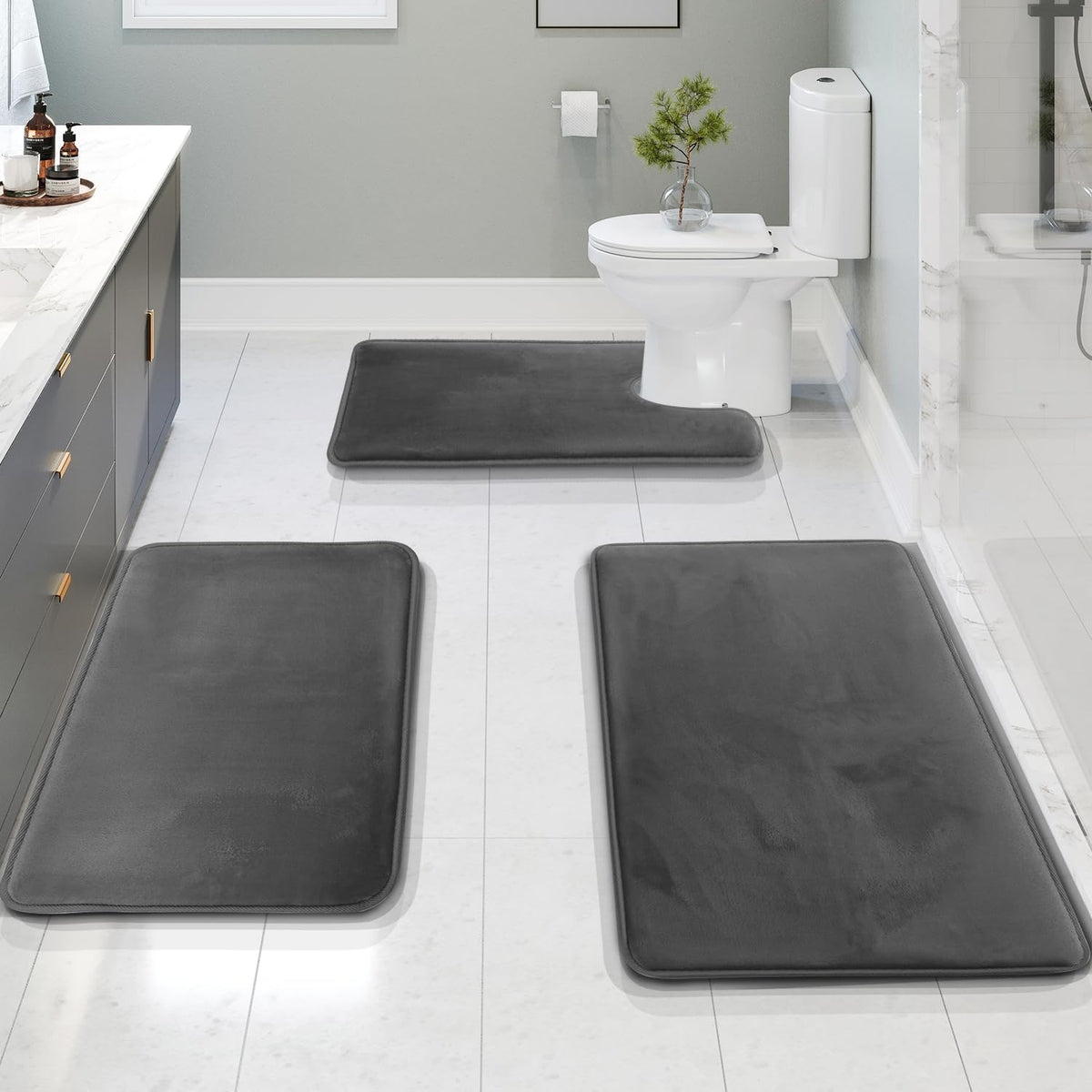 Dark gray bath mat set on a white tile floor