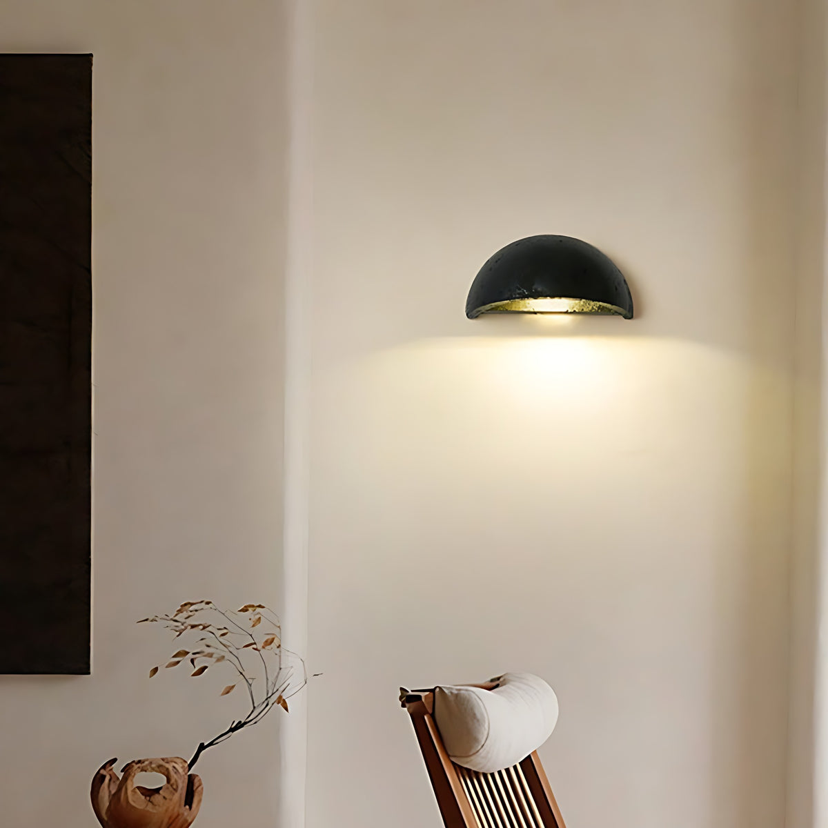 Black travertine Mira LED wall sconce lit, glow down the wall
