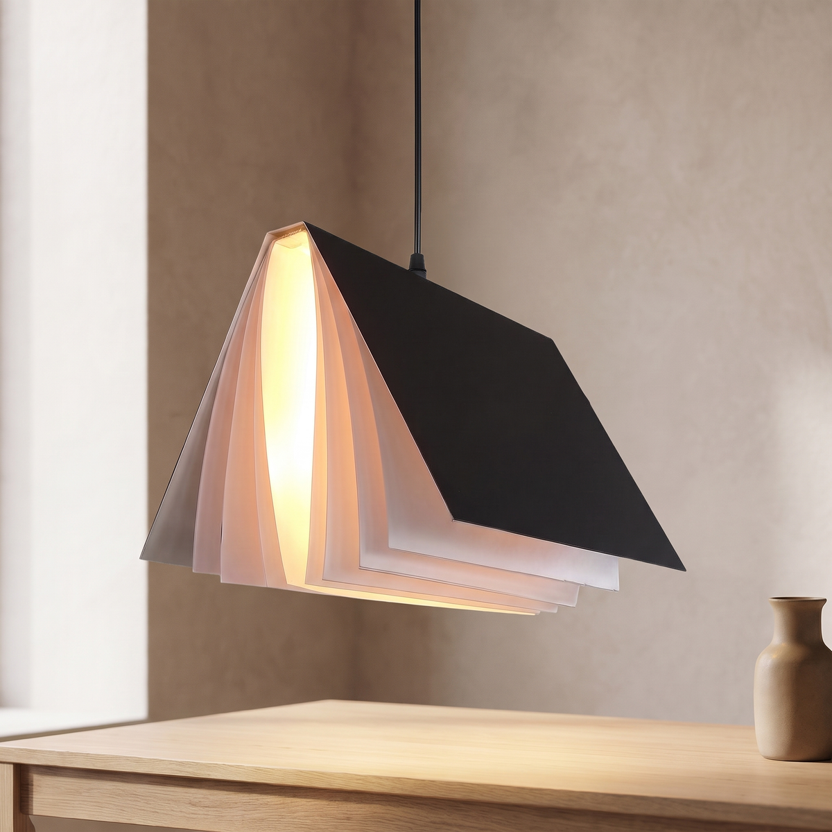 Nesna book pendant light in black, lit above an oak desk