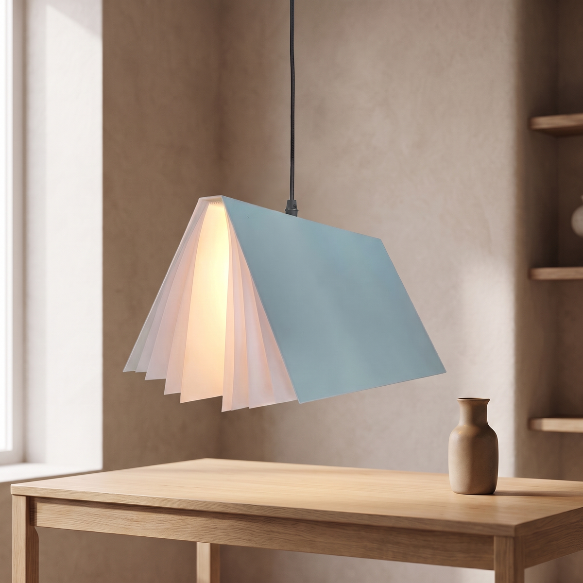 Nesna book pendant light in blue, lit above an oak desk