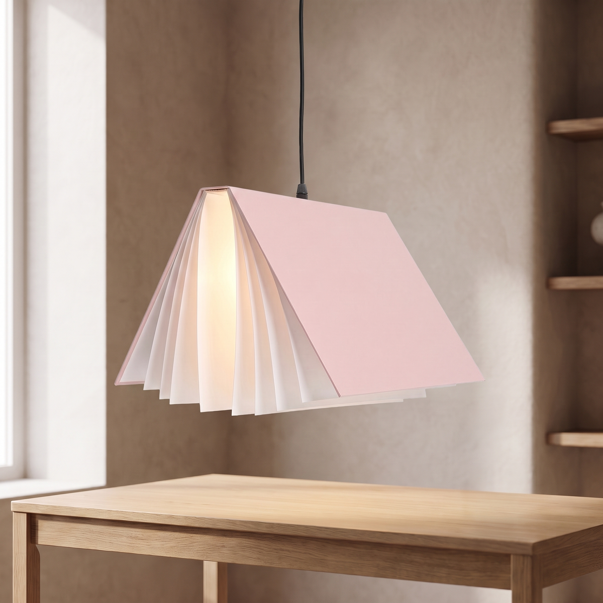 Nesna book pendant light in pink, lit above an oak desk