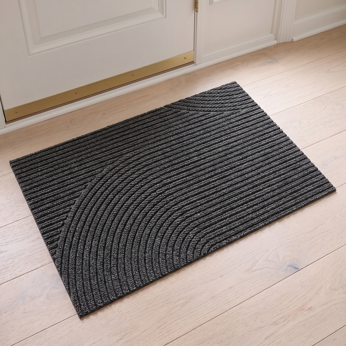 Non slip door mat in gray inside a white front door