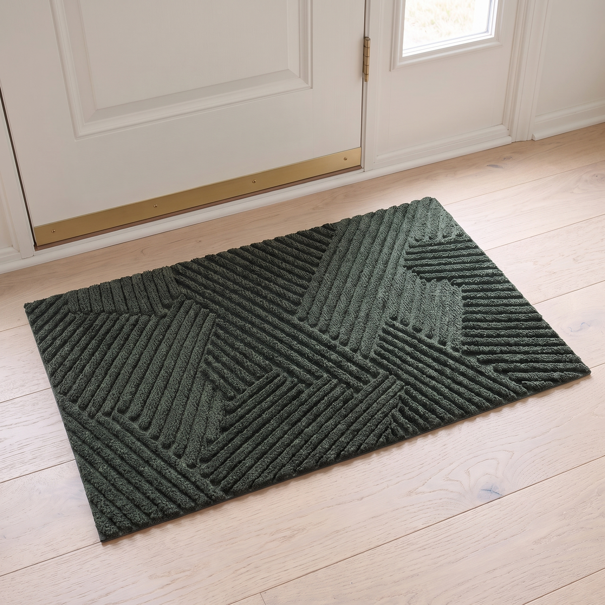 Non slip door mat in green inside a white front door