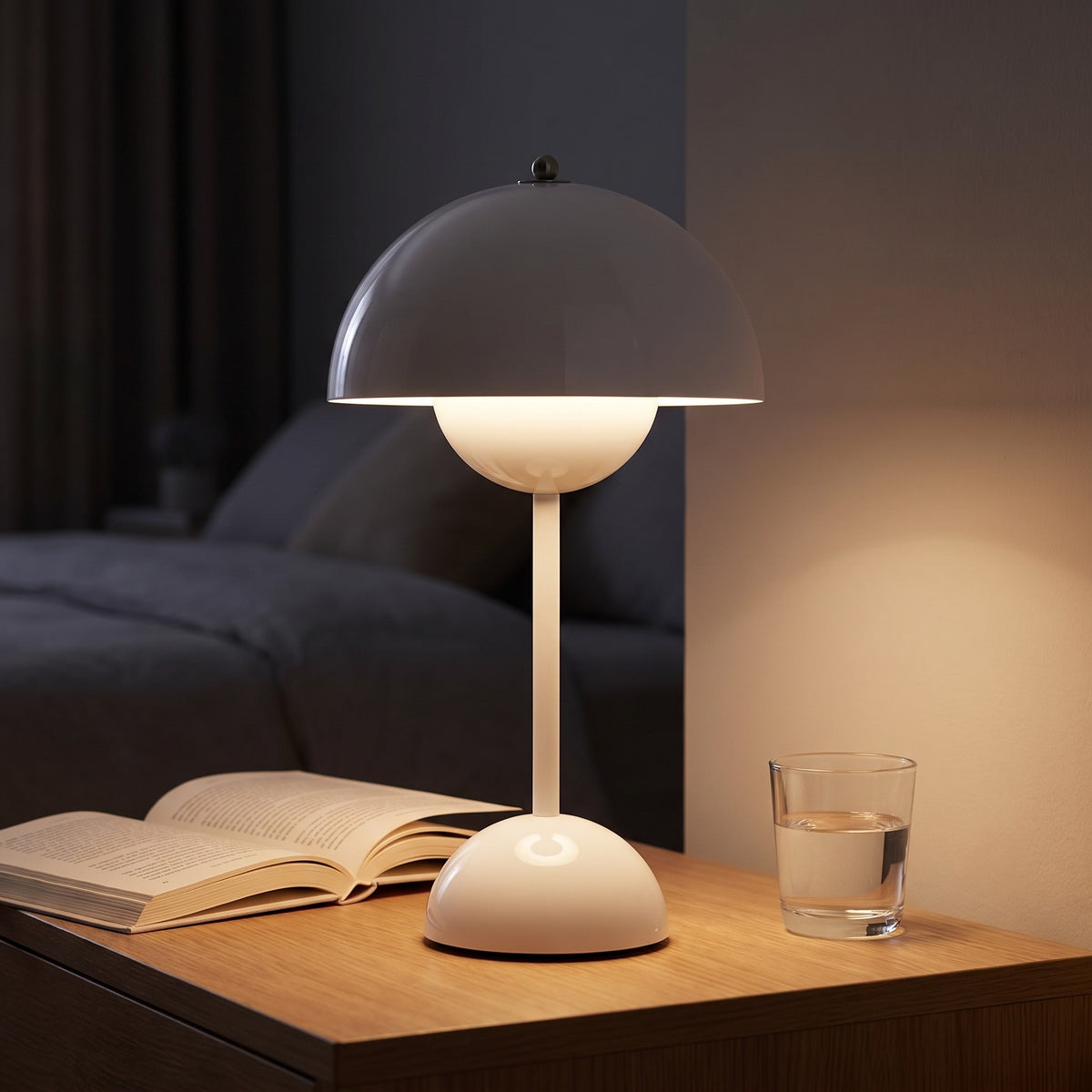 Oona table lamp in white on a nightstand beside the bed at night