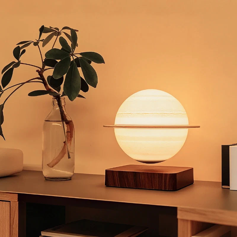 Orsa Saturn lamp floating above a walnut base on a shelf