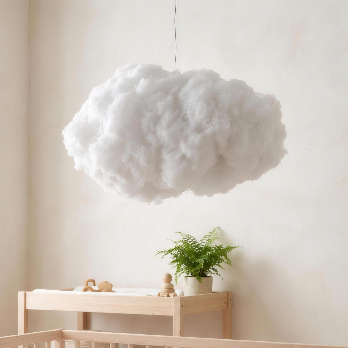 Petra cloud pendant light hanging over a crib in a nursery