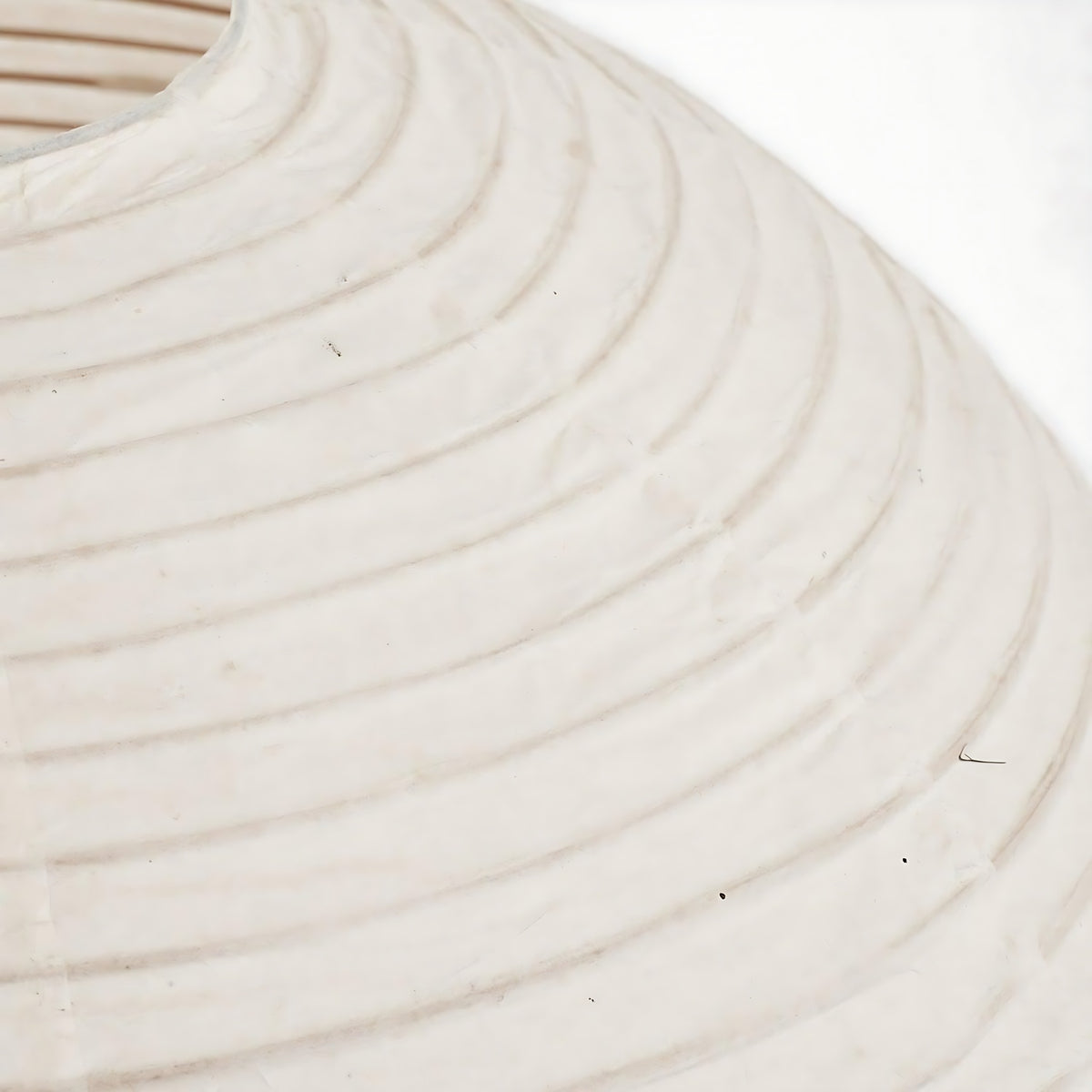 Close view of the Pia pendant light, white washi paper globe showing the paper ribs
