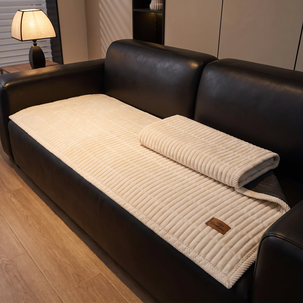 Quilted couch cover with one end folded back on the sofa seat