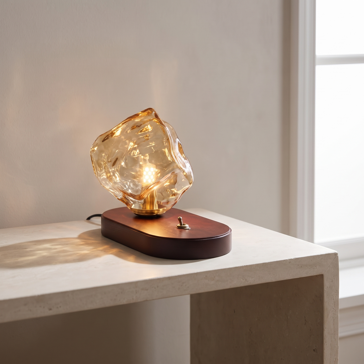 Ribe amber glass table lamp lit on a limestone console