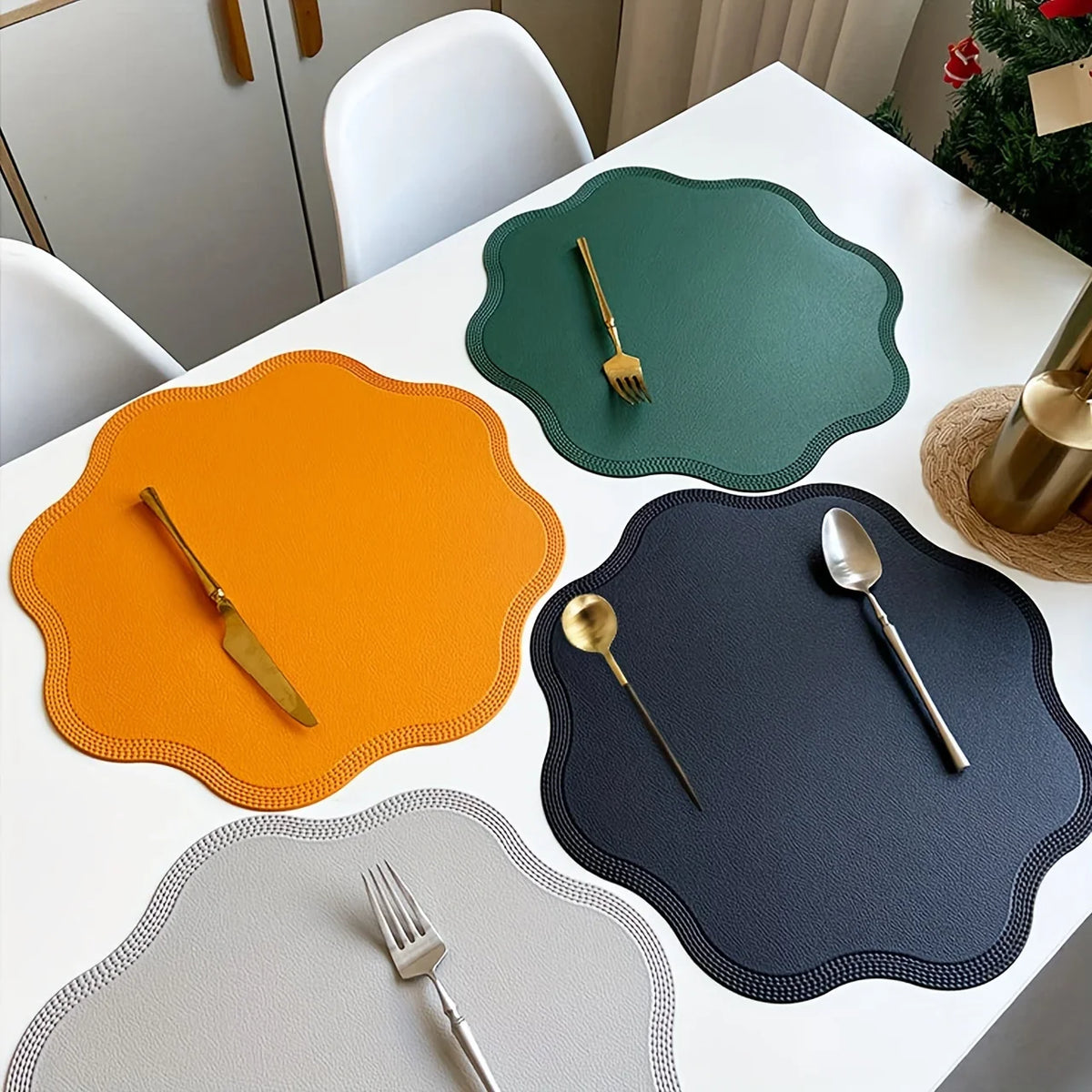 Yellow, green, black and gray scalloped placemats on a white table with cutlery