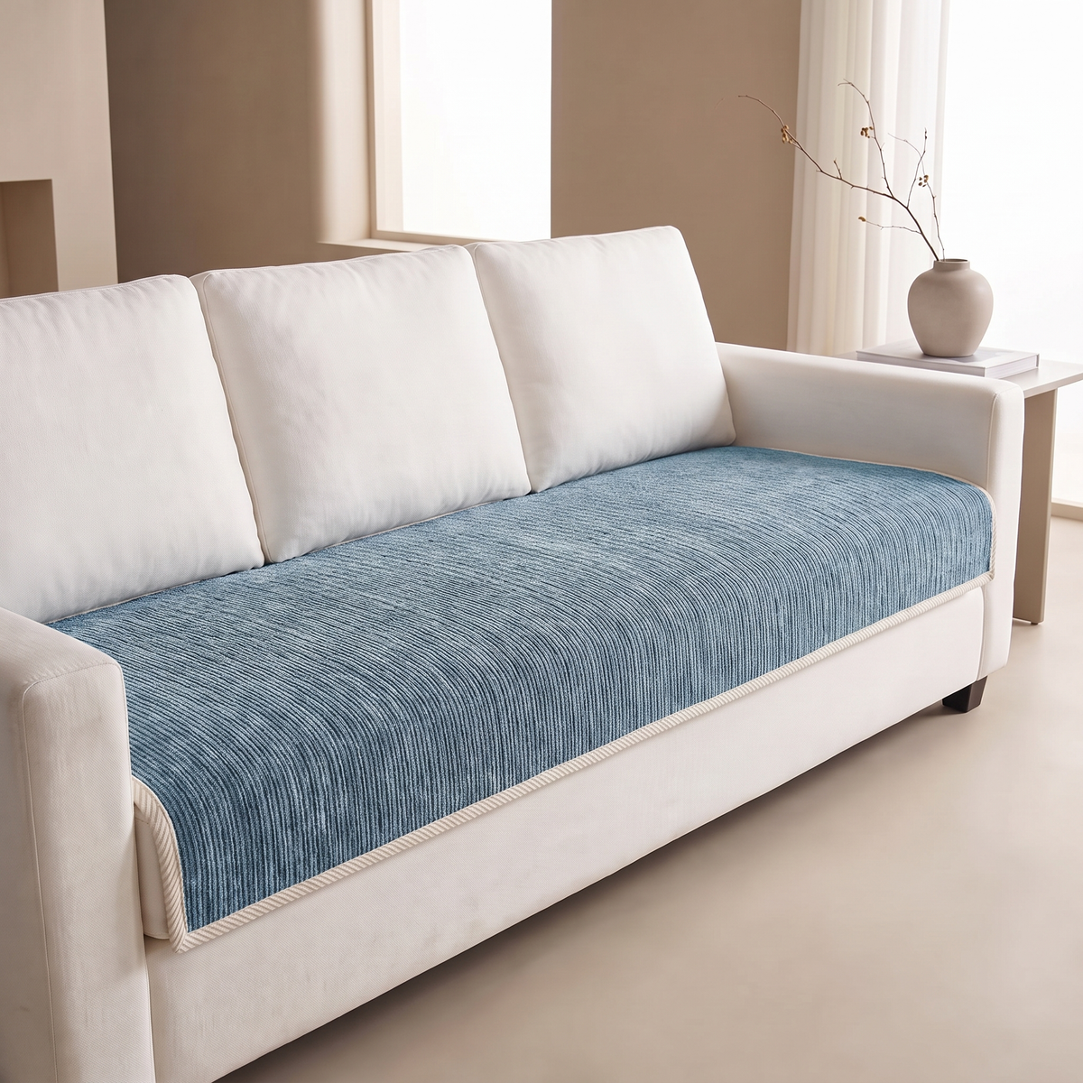 Blue ribbed sofa cover fitted over the seat of a white sofa